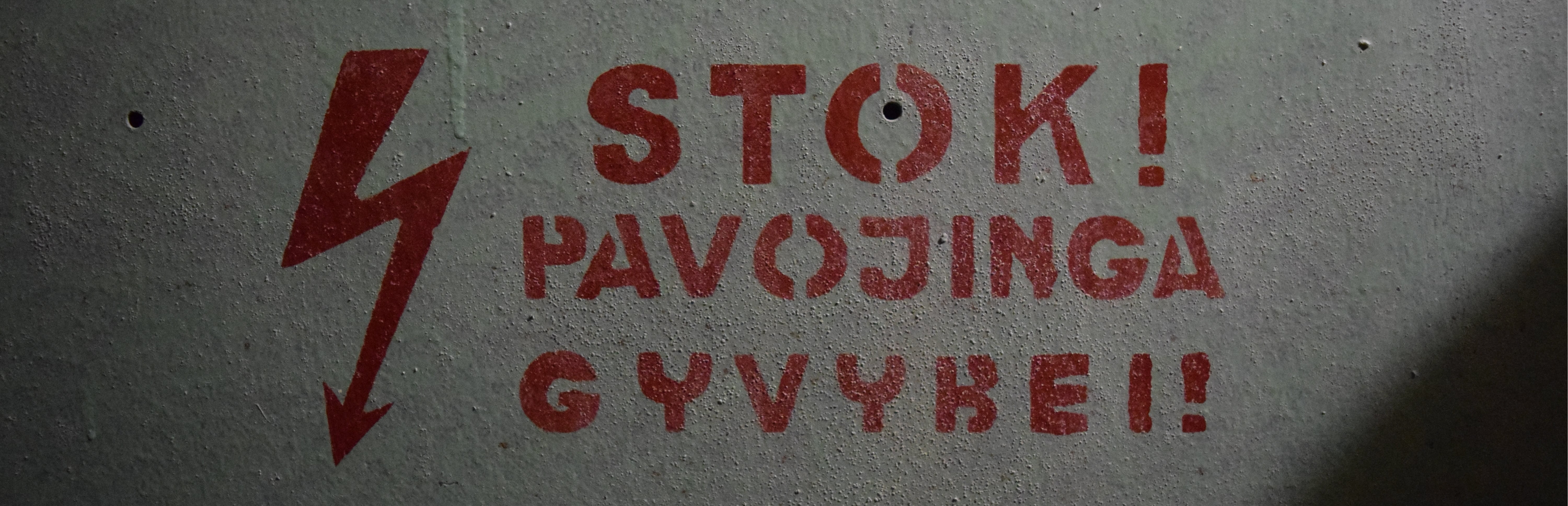 Betoninė siena su užrašu Stok! Pavojinga gyvybei!